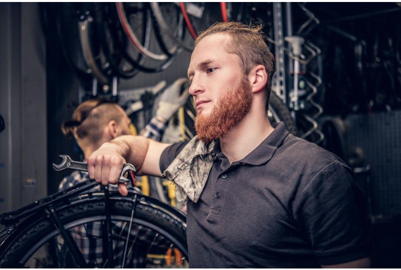 Mechaniker mit E-Bike in Werkstatt